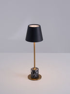 A Clérachic marble table lamp lit against a plain grey backdrop, cropped close to show the full stem and shade.