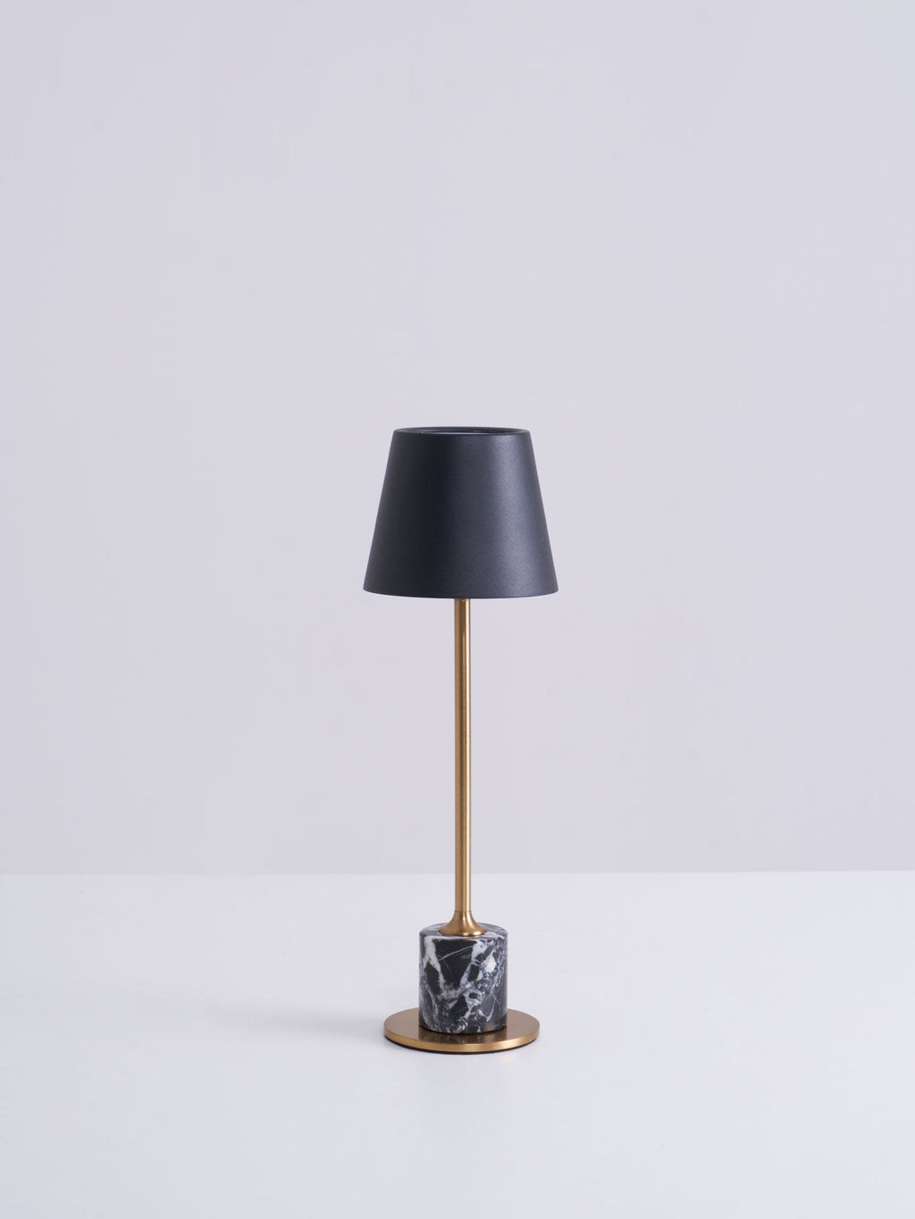 A Clérachic marble table lamp shown in full against a plain grey studio background, lit and photographed straight on.