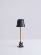 A Clérachic marble table lamp shown in full against a plain grey studio background, lit and photographed straight on.