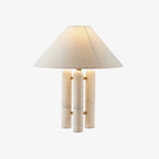 Clérachic table lamp with three white marble columns and a wide cream shade, alone on a plain studio background.