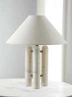 Clérachic table lamp on the marble table, a tall vertical crop emphasising the shade's height above the columns.