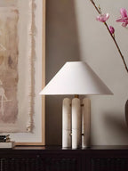 Closer crop of the same console scene, the magnolia branch and stacked books shown beside the Clérachic lamp.