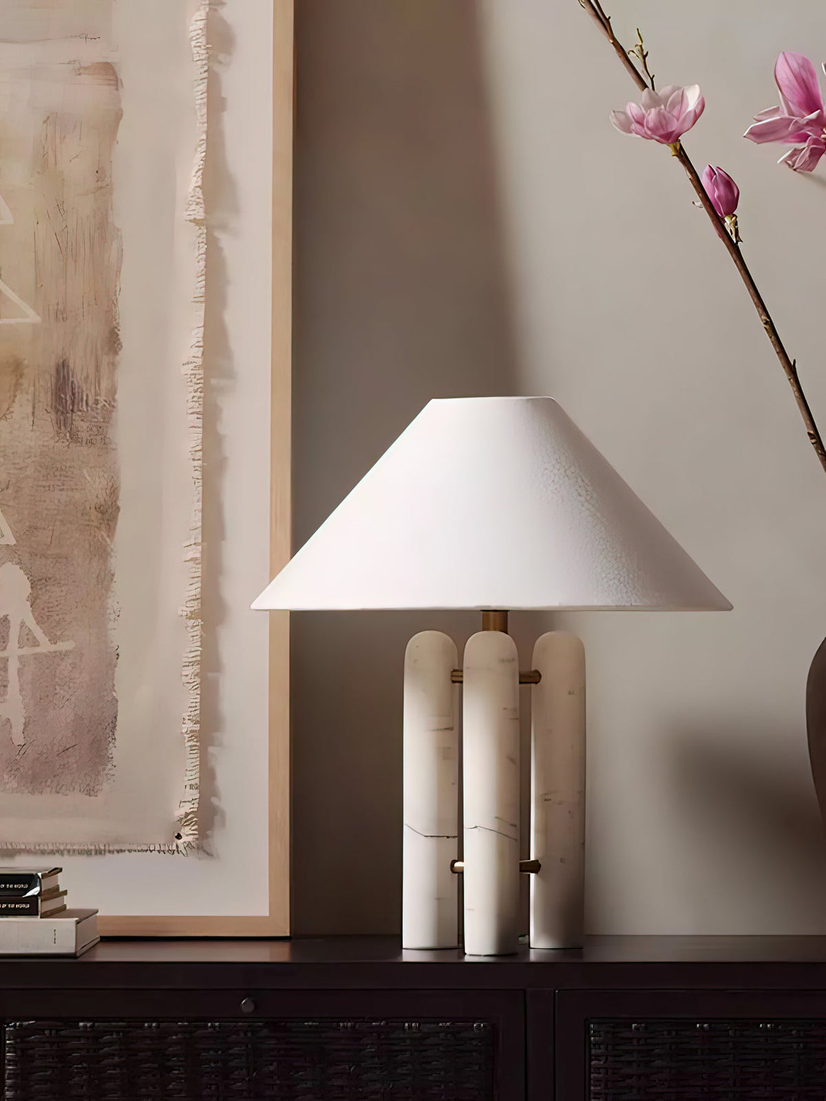 Closer crop of the same console scene, the magnolia branch and stacked books shown beside the Clérachic lamp.