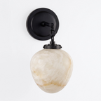 Studio shot of this Clérachic wall sconce in black finish, its teardrop alabaster shade suspended from a chain.
