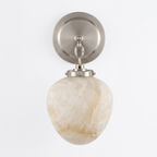 Front view of this Clérachic wall sconce in satin nickel finish, its alabaster shade catching light from below.