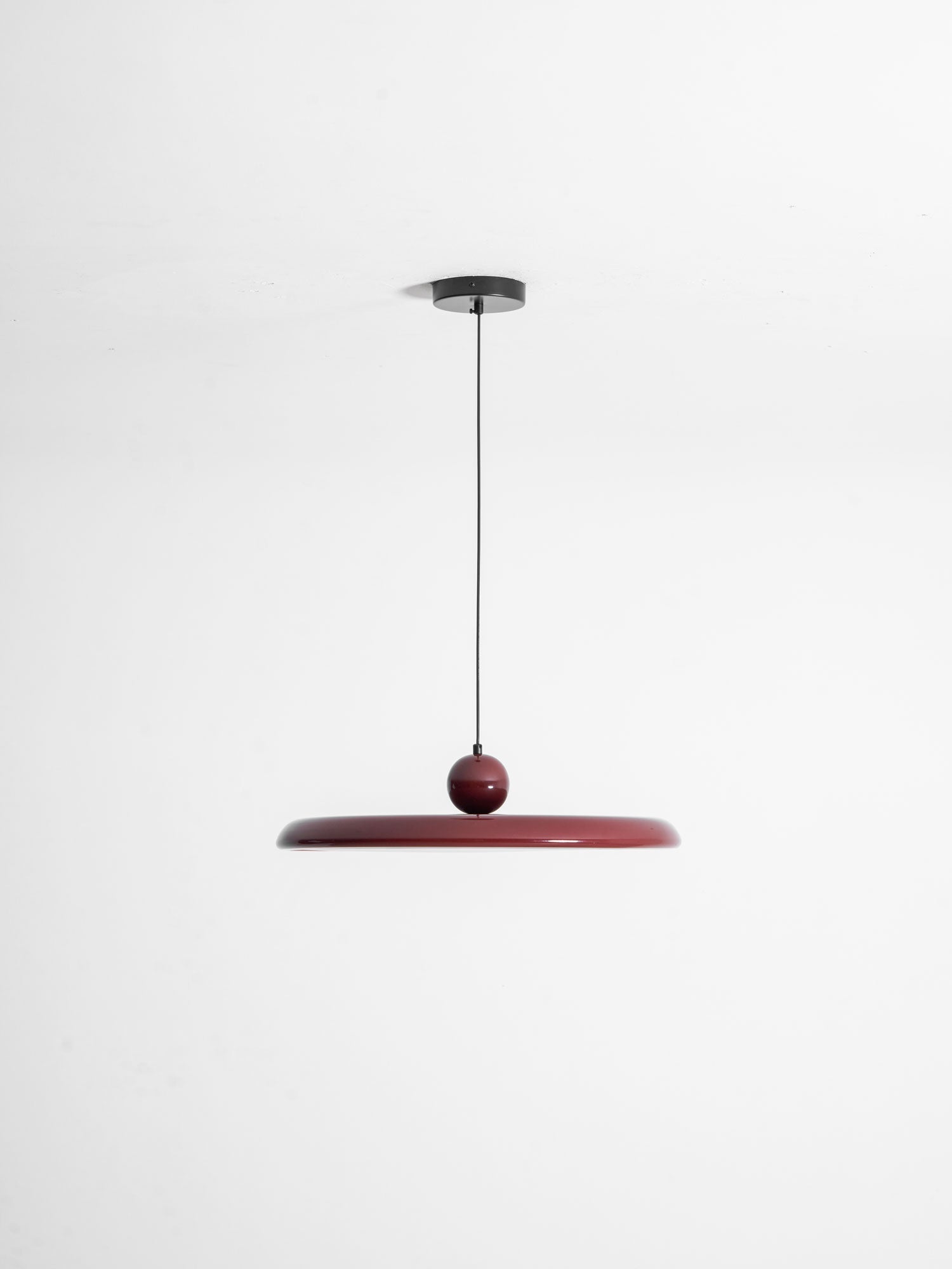 Round disc pendant light shown on a clean studio background