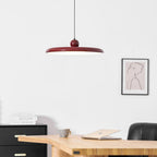 Round disc pendant light suspended low in a styled room