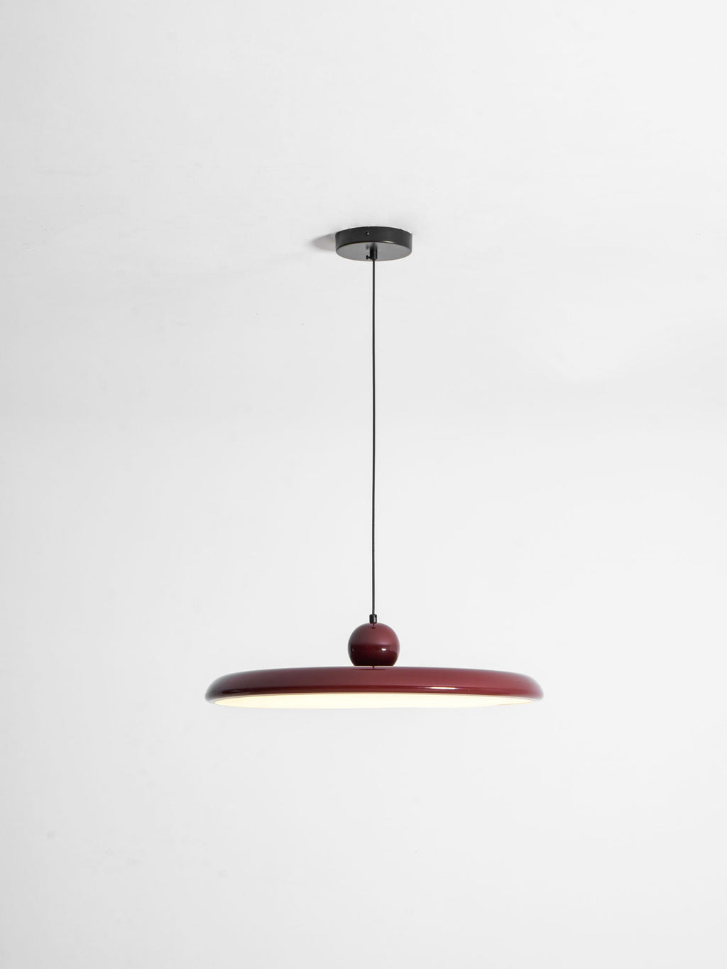 Round disc pendant light close view of the lit white disc