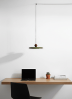 Round disc pendant light shown on a plain studio background