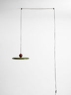 Round pendant light glowing in a warmly lit room corner