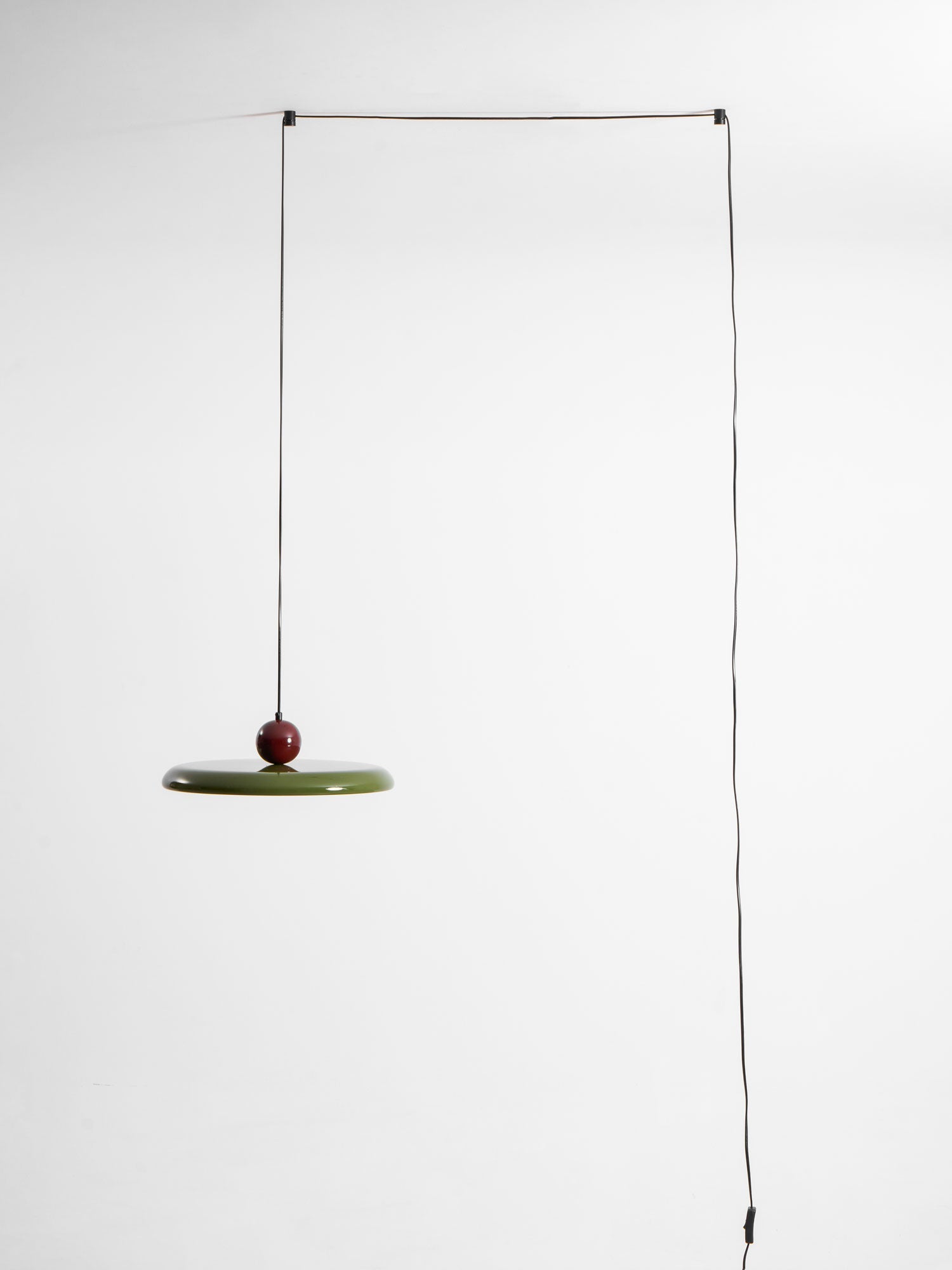 Round pendant light glowing in a warmly lit room corner
