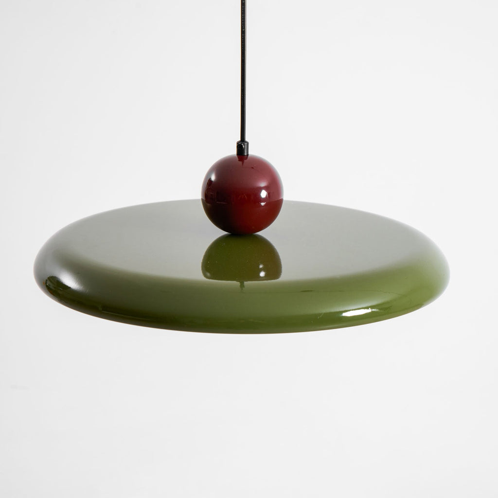 Disc pendant light casting an even glow across a wall
