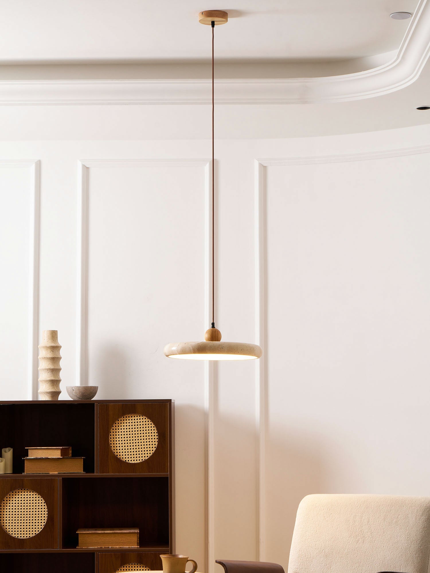 Travertine stone pendant light with warm wood frame glowing softly