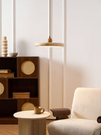 Round travertine pendant light with warm wood frame in a hallway
