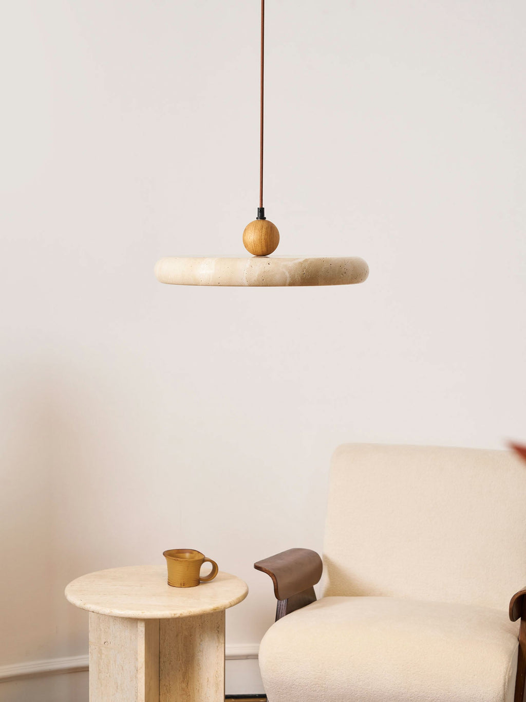 Travertine pendant light with wood frame casting a warm glow