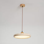 Travertine stone pendant light with wood frame glowing over a table