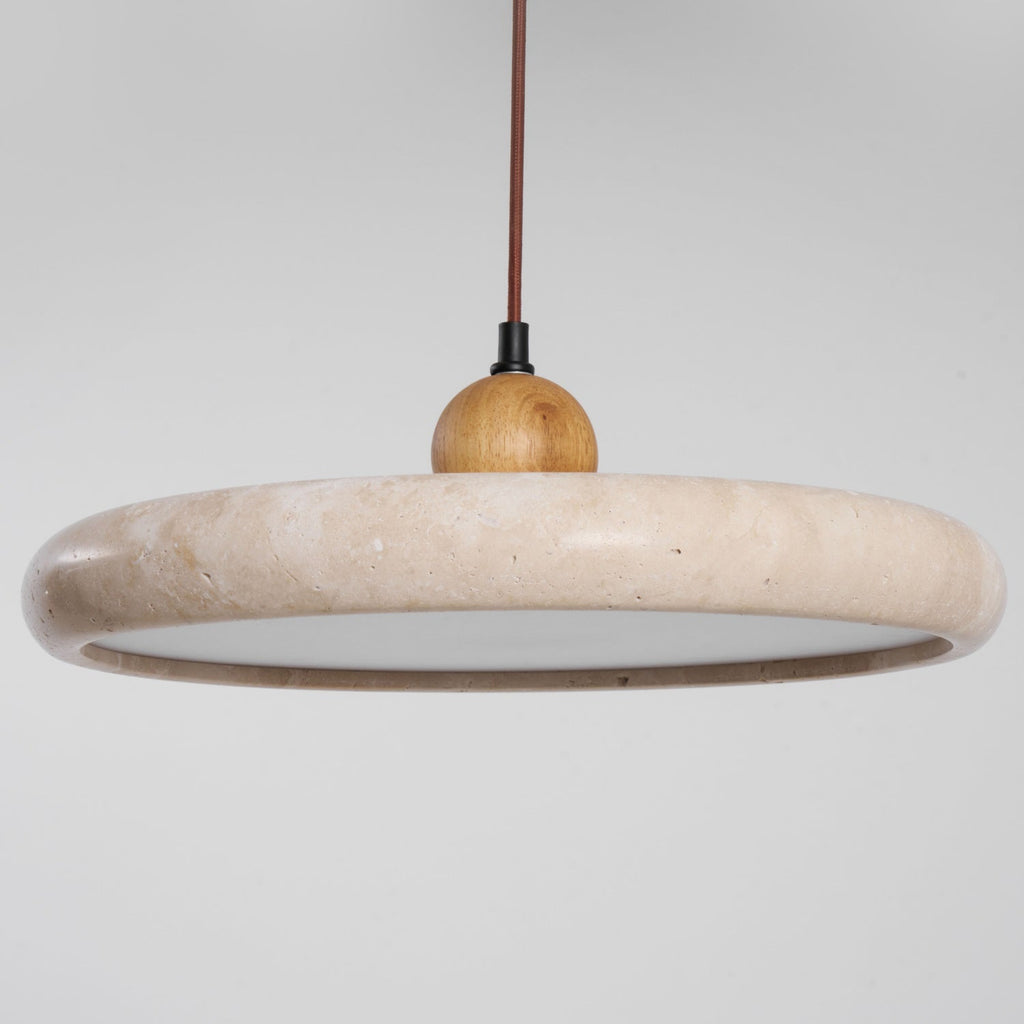 Travertine stone pendant light hanging over a dining area