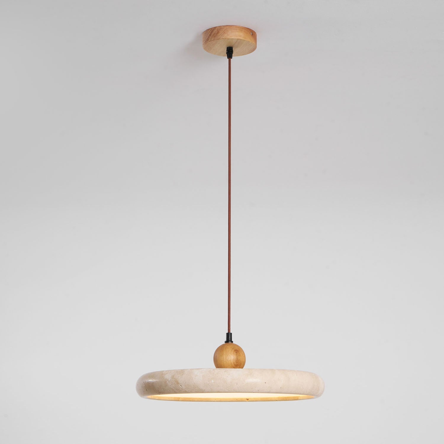 Travertine pendant light shown with adjustable suspension cable