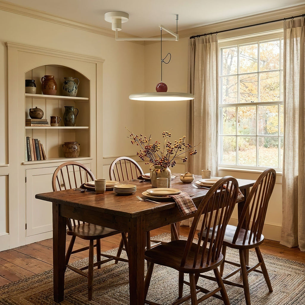 Mid-century disc pendant light glowing warmly over a desk