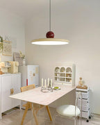Round disc pendant light lit gently in a styled interior
