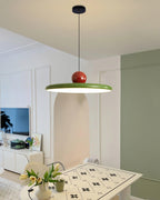 Round disc pendant light glowing softly above a table