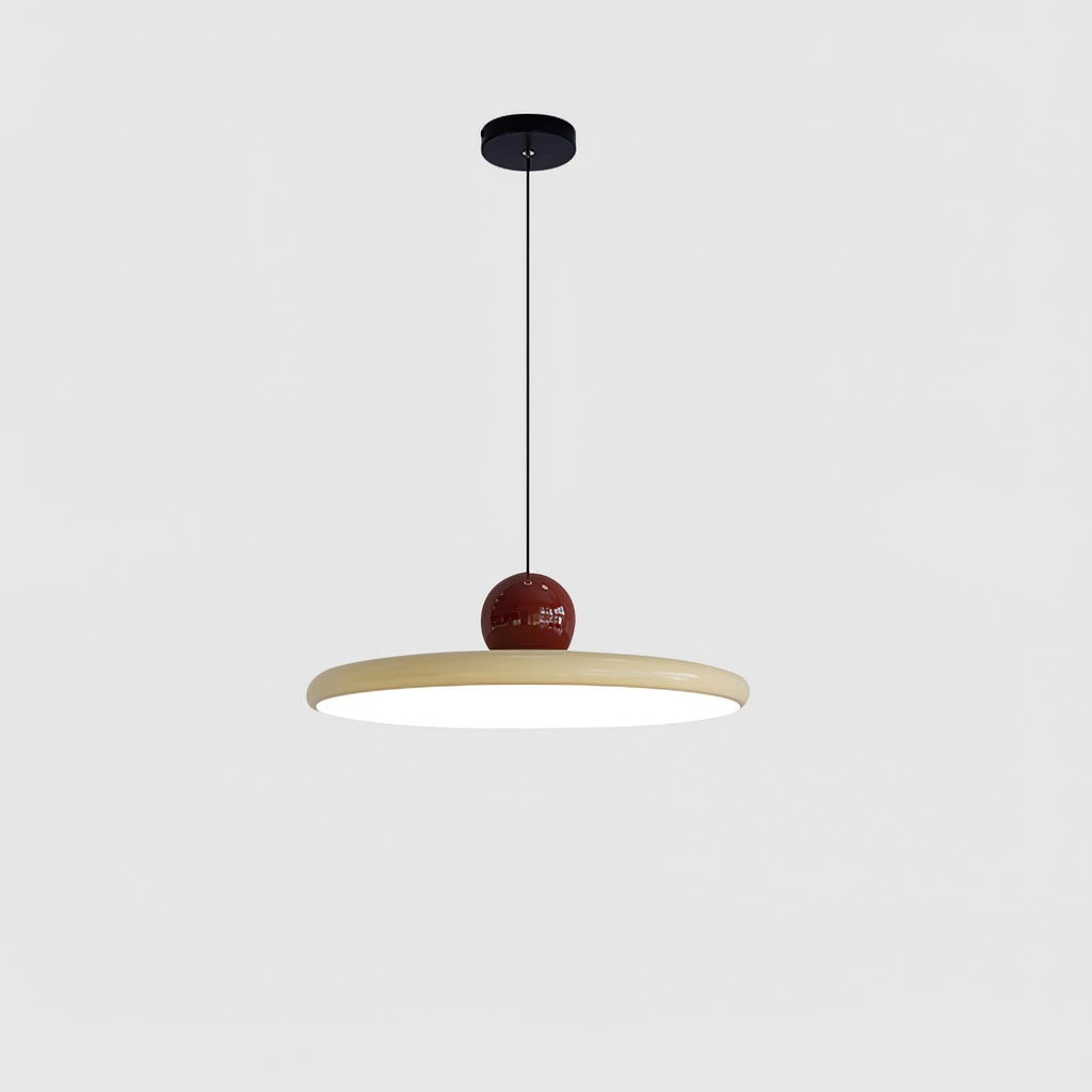 Round disc pendant light suspended above an island worktop