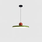Round disc pendant light glowing warmly over a dining table