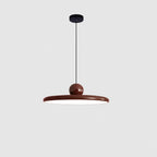 Round disc pendant light with white shade lit softly in a room