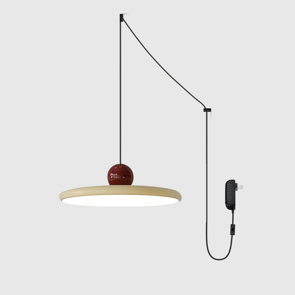 Round disc pendant light glowing softly above a styled interior