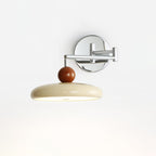 Round disc plug-in wall lamp shown on a neutral backdrop