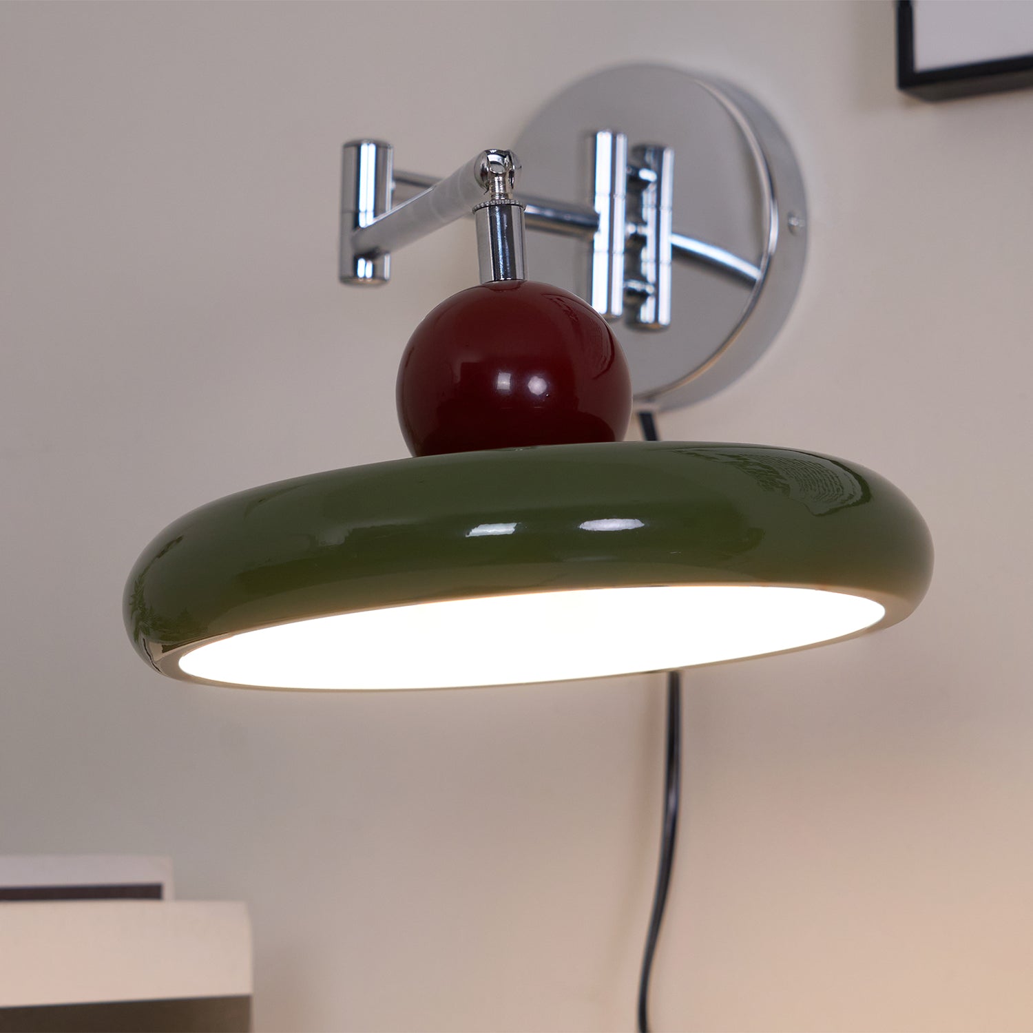 Round disc wall lamp front view lit on a plain wall