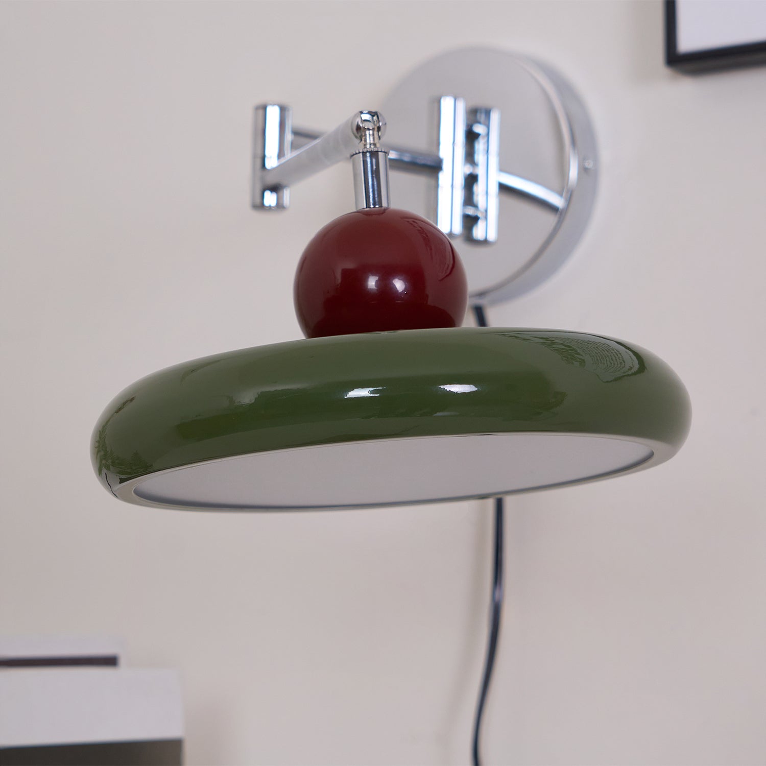 Round disc wall lamp glowing softly in a reading corner