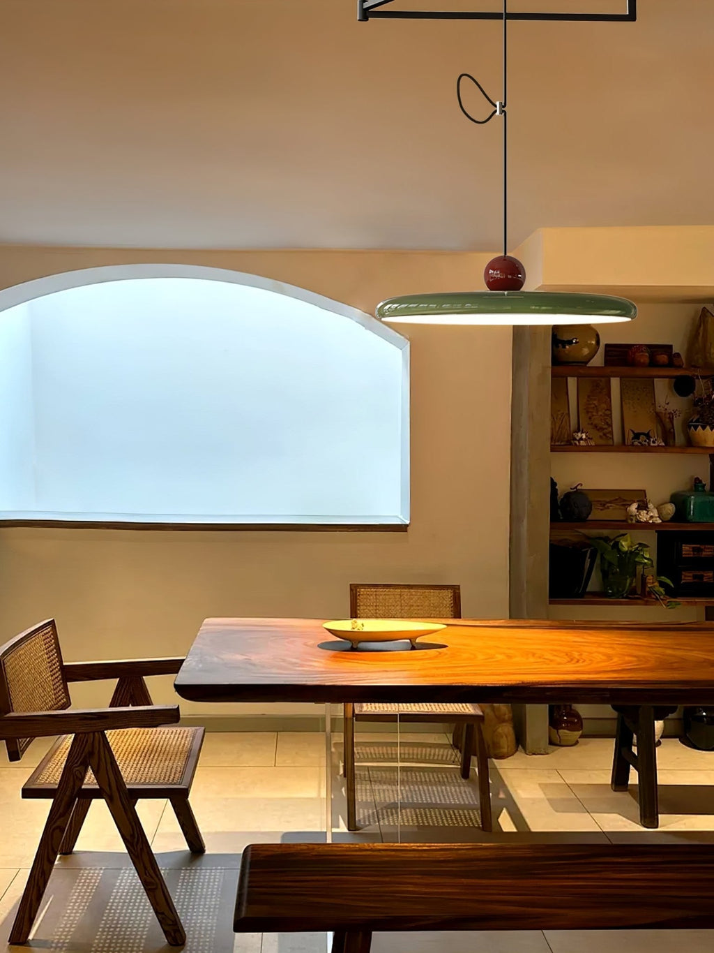 Mid-century swing arm pendant light glowing over a table surface