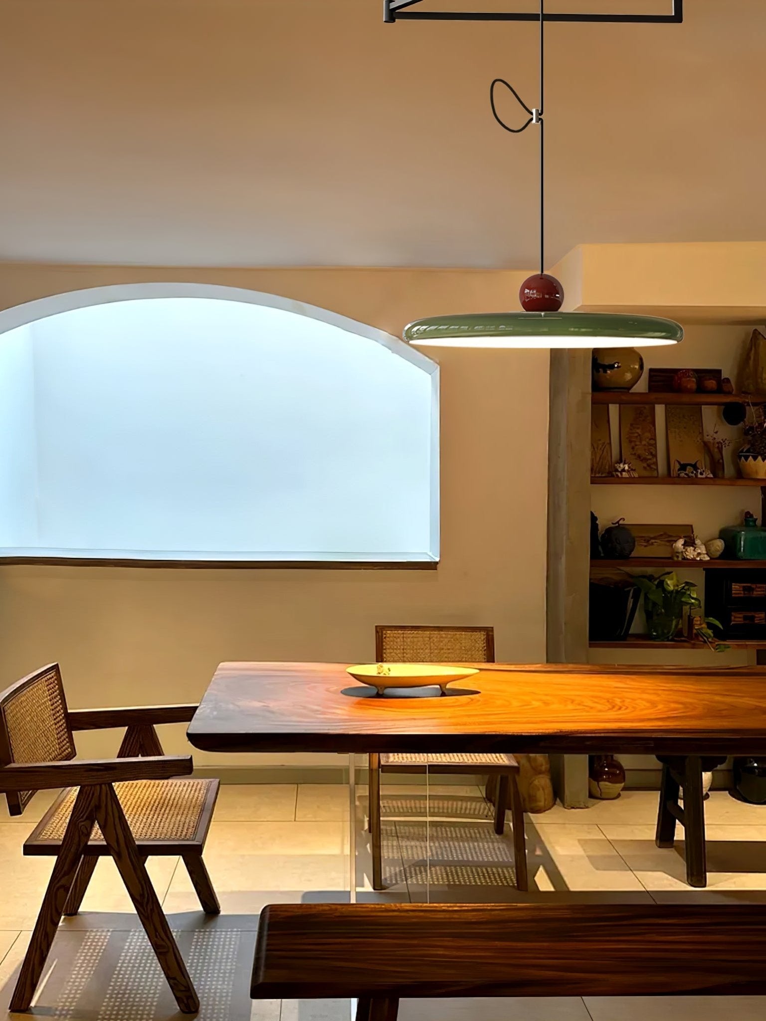 Mid-century swing arm pendant light glowing over a table surface