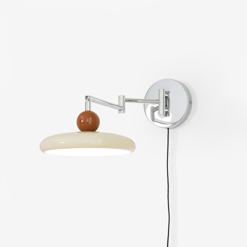 Round disc wall lamp with beige shade lit beside a sofa