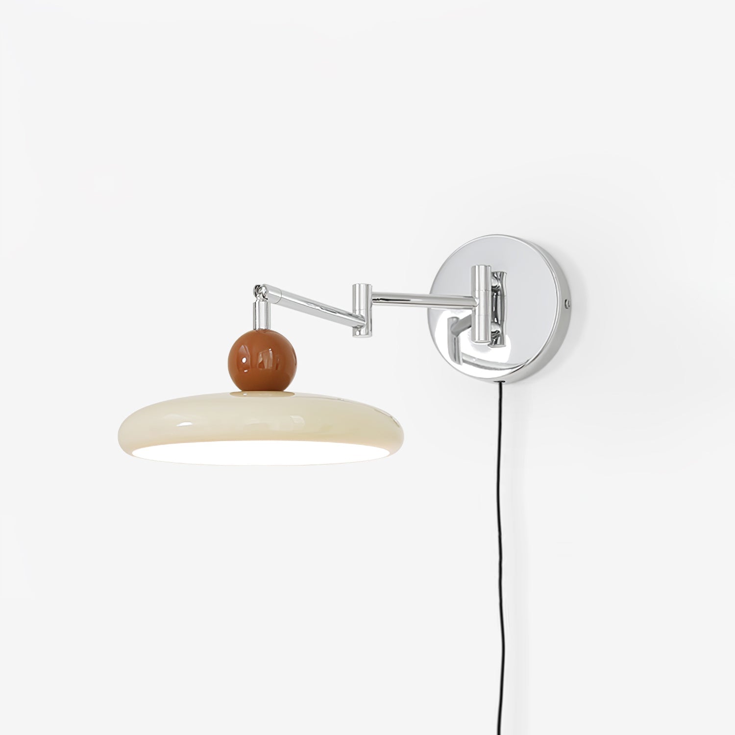 Round disc wall lamp with beige shade lit beside a sofa