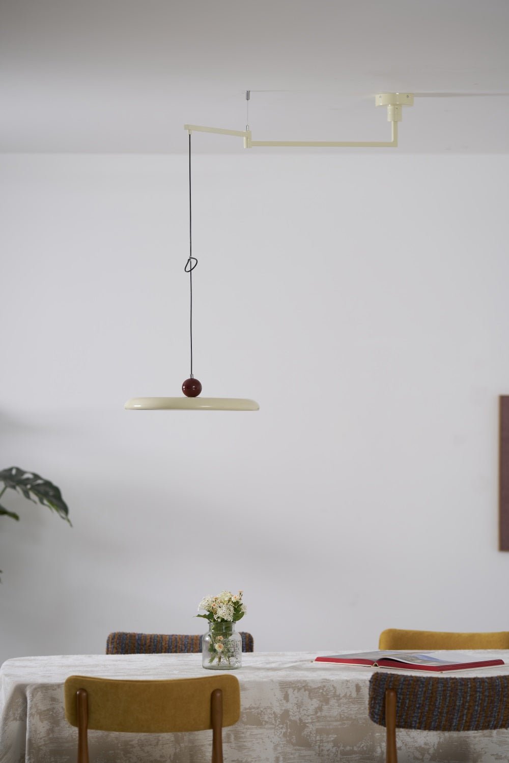 Swing arm pendant light with lit acrylic disc and balancing sphere