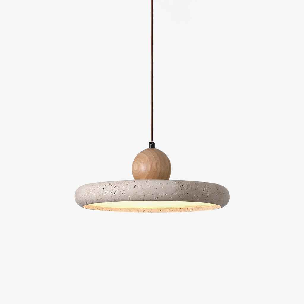 Natural travertine disc pendant light lit warmly in a living room