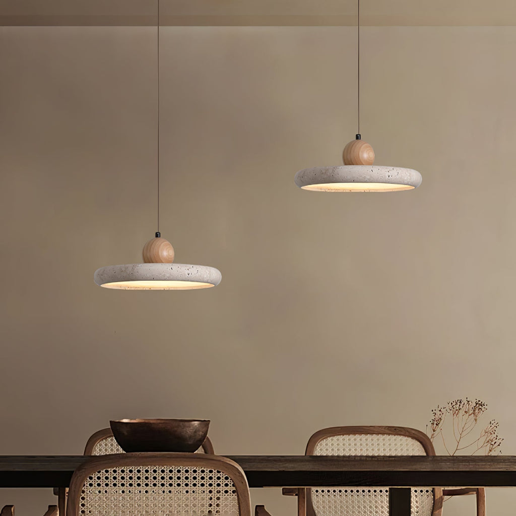 Travertine stone pendant light lit above a styled dining setting