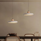 Travertine stone pendant light lit above a styled dining setting