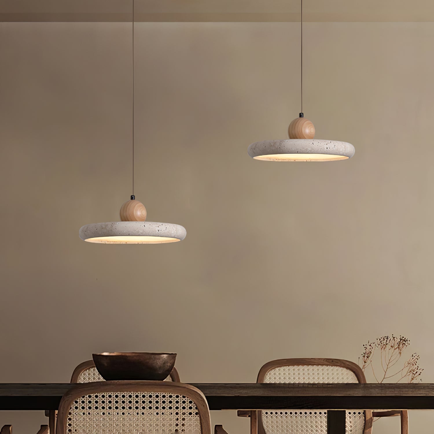 Travertine stone pendant light lit above a styled dining setting