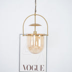 Side profile of amber glass pendant light with slim gold frame