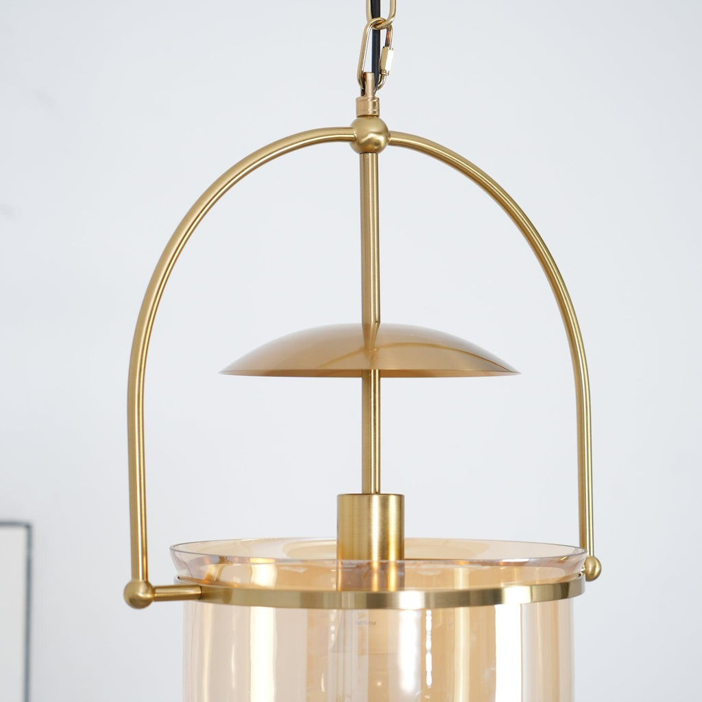 Gold frame pendant light with amber glass shade and black cord