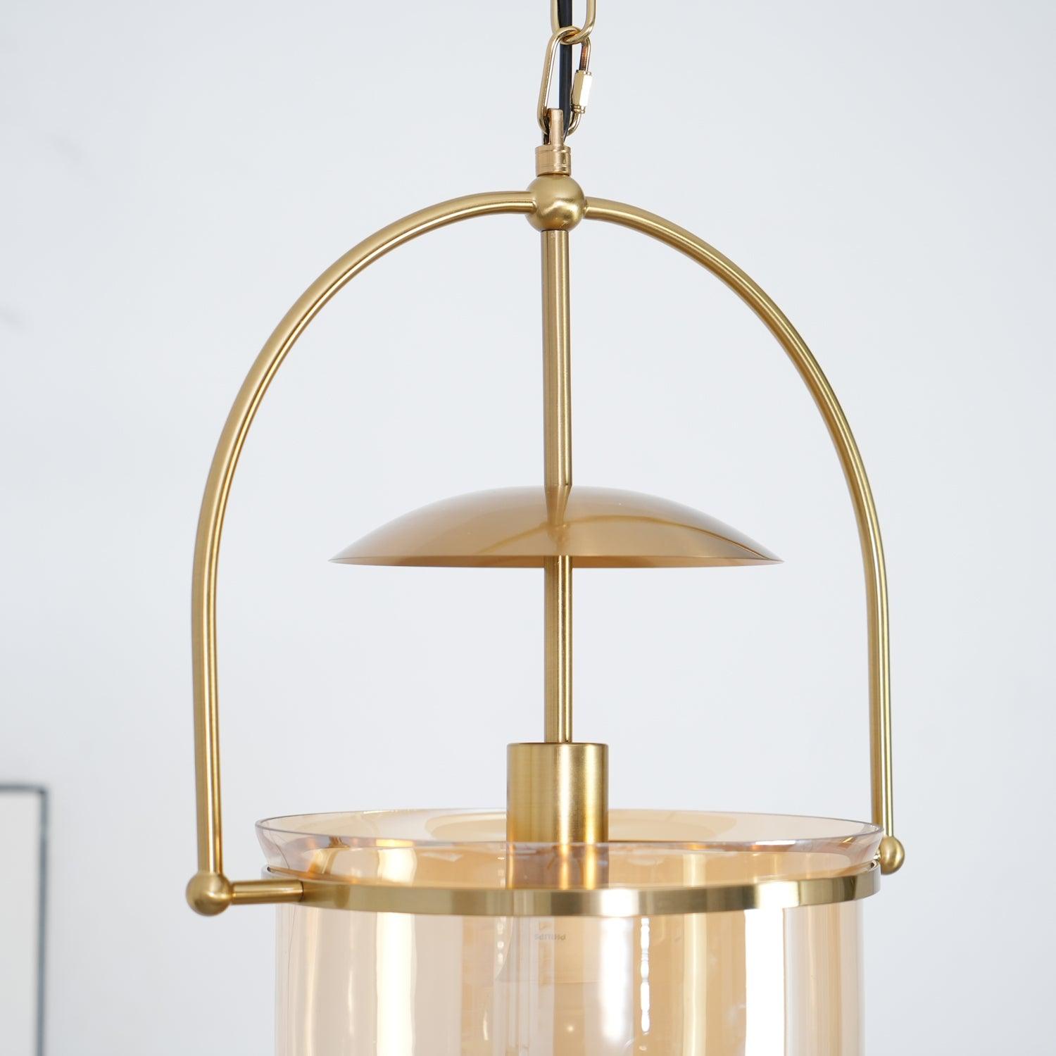 Gold frame pendant light with amber glass shade and black cord