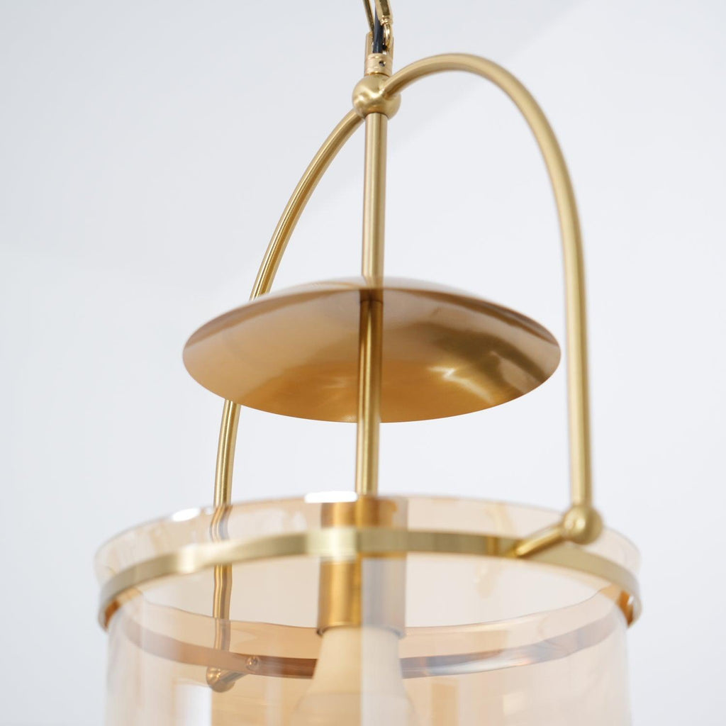 Close detail of amber glass shade edge on a gold pendant frame