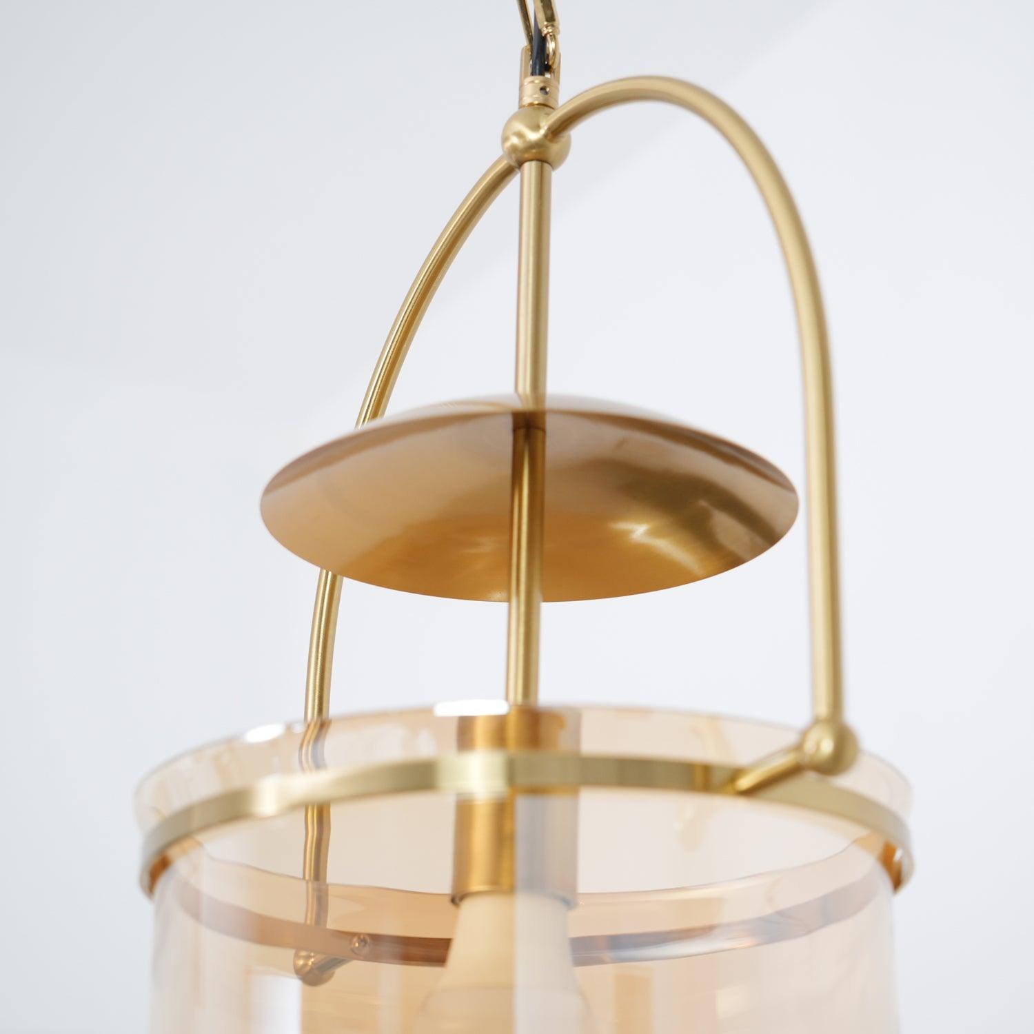 Close detail of amber glass shade edge on a gold pendant frame