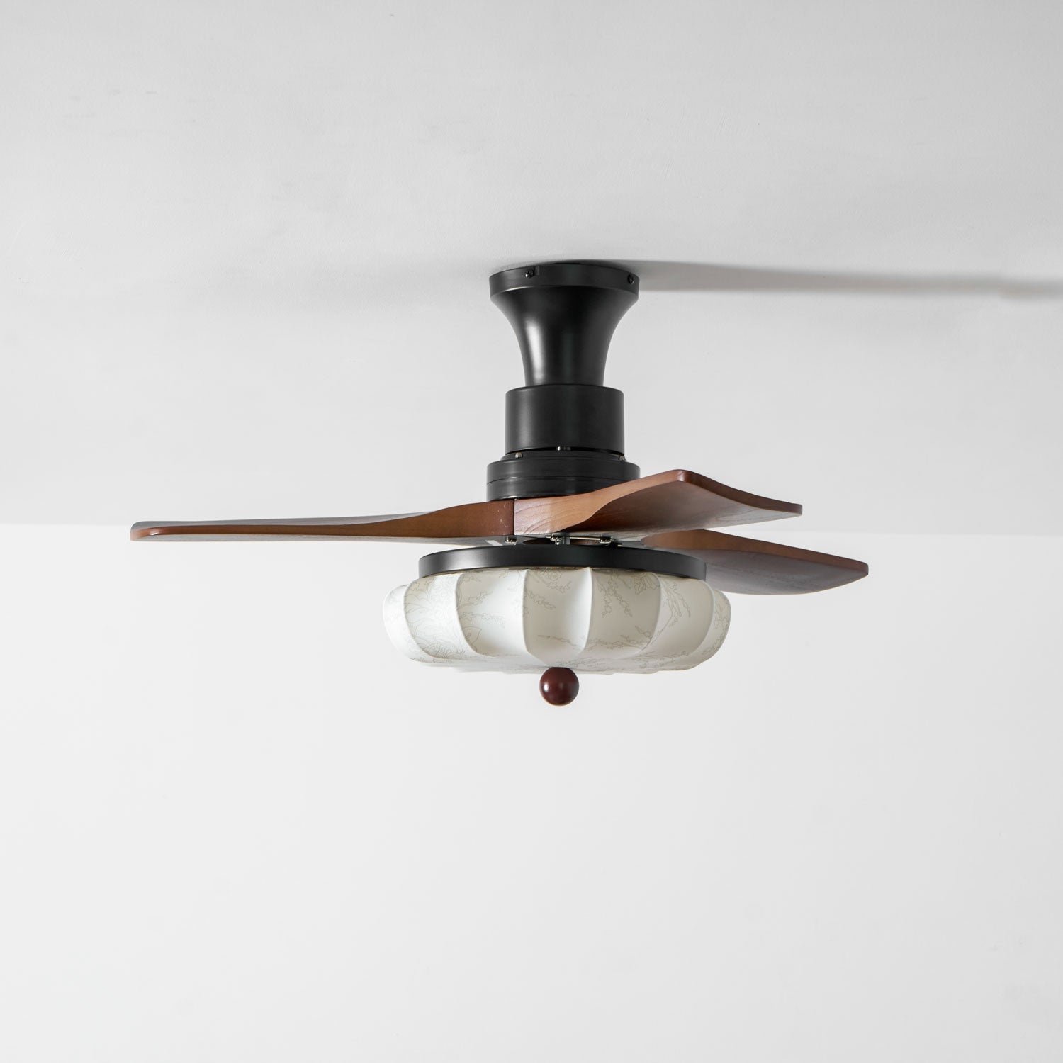 Walnut-blade ceiling fan with lotus shade in a bedroom setting