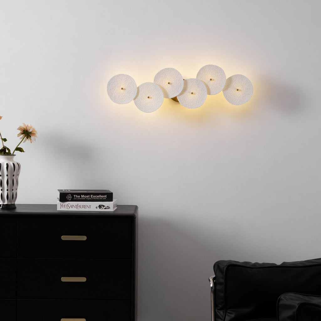 Lotus petal wall lamp glowing softly in white ceramic