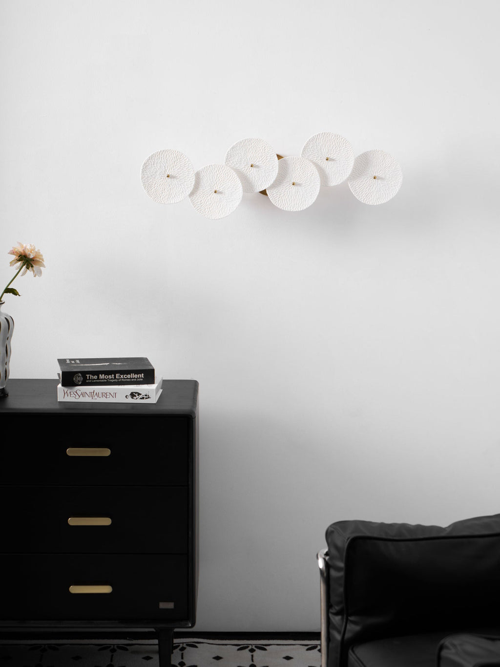 White ceramic lotus petals climbing a gold wall spine