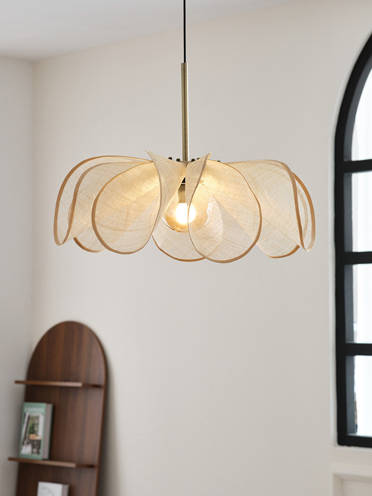 Beside a wood bookshelf and arched window, this Clérachic pendant's beige petals catch warm light from within.